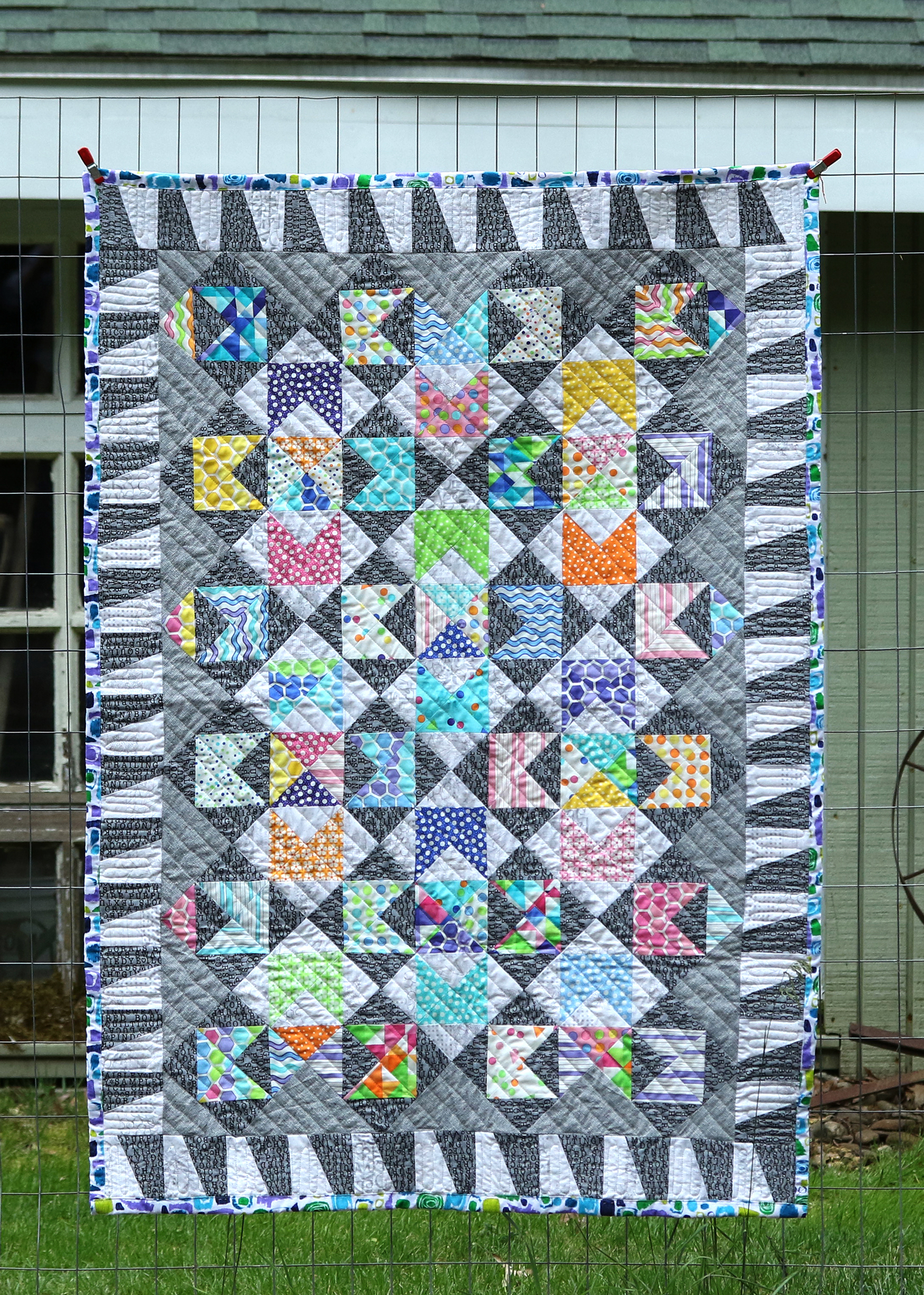 A Love Note baby quilt with text and bright high contrast dots and hexegons